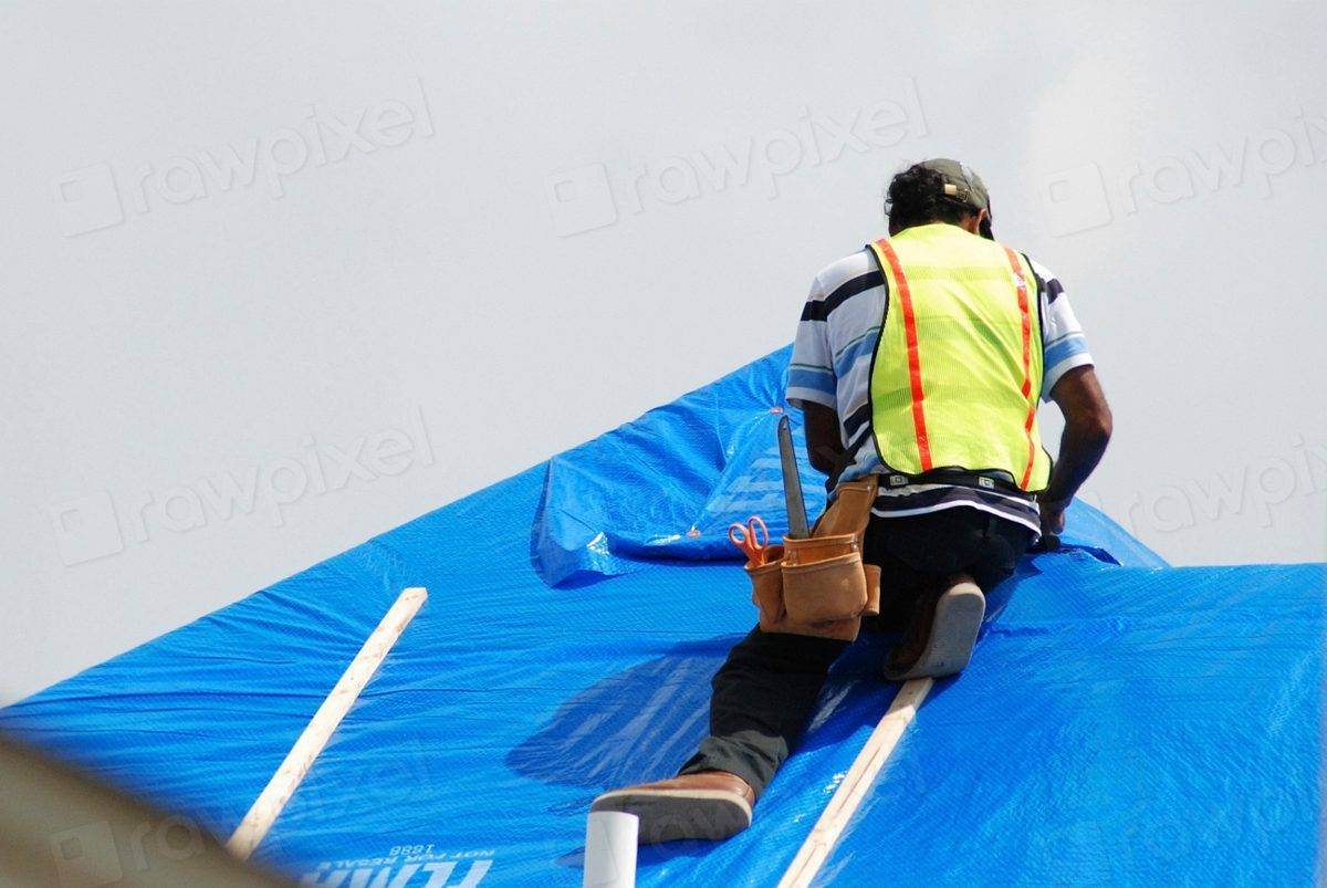 Roofer installing an emergency tarp
